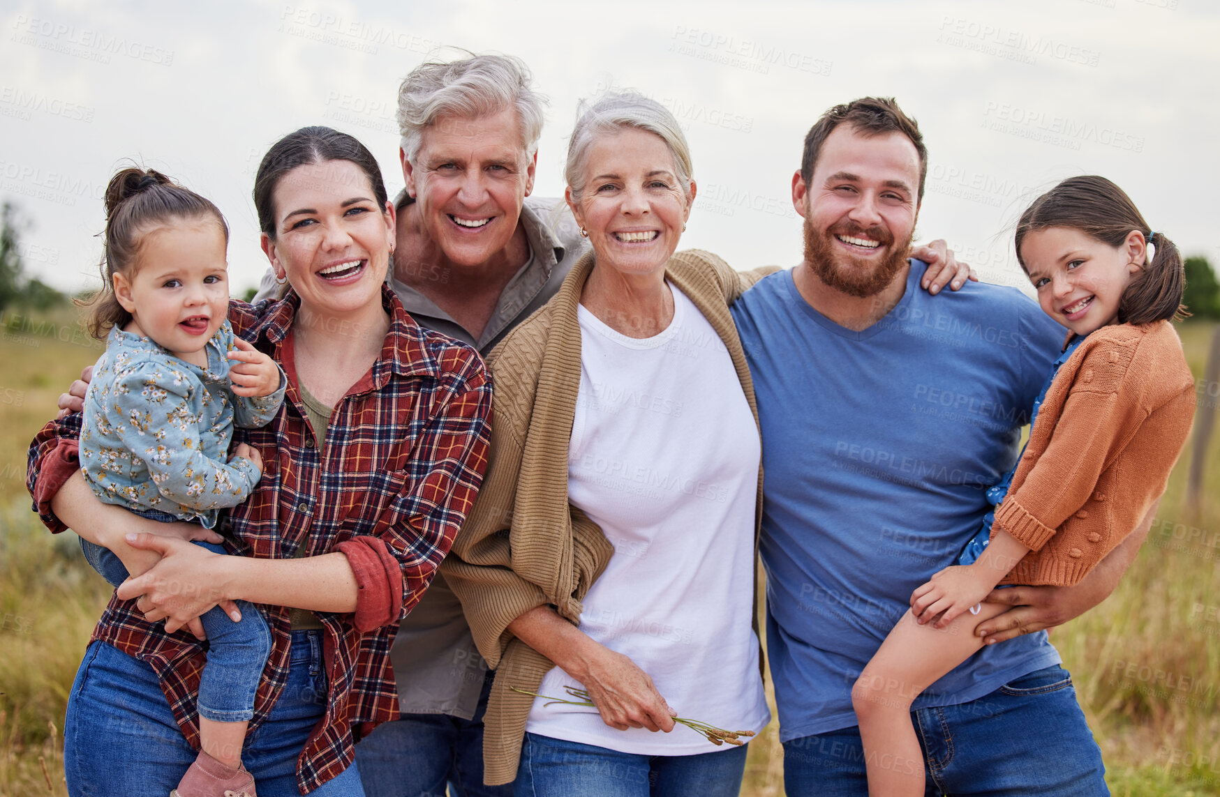 Buy stock photo Shot of a multi-generational family standing together on a farm