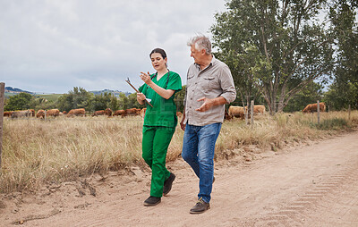 Buy stock photo Shot of a veterinarian talking to a mature man on his farm