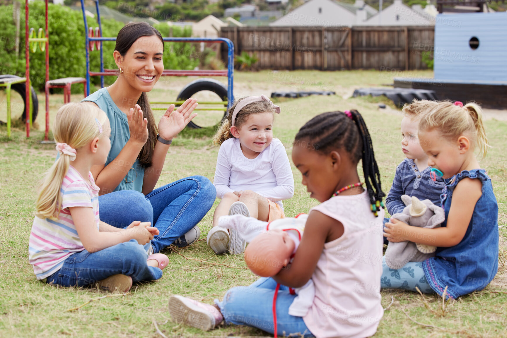 Buy stock photo Shot of a teacher spending time outside with preschool children