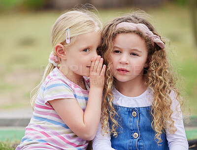 Buy stock photo Shot of a little girl whispering in her friend's ear