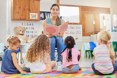 Buy stock photo Shot of a young woman reading to her preschool students