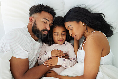 Buy stock photo Shot of a young family taking a nap together at home