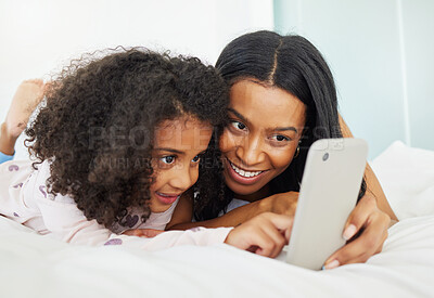 Buy stock photo Shot of a young mother and daughter using a phone together at home