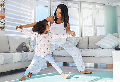 Buy stock photo Shot of a young mother and daughter doing yoga at home