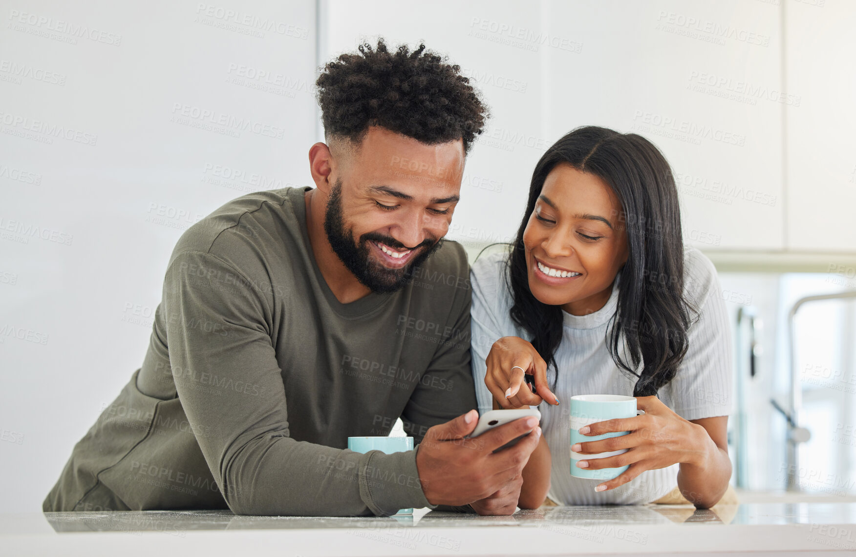 Buy stock photo Shot of a young couple using a phone while drinking coffee at home