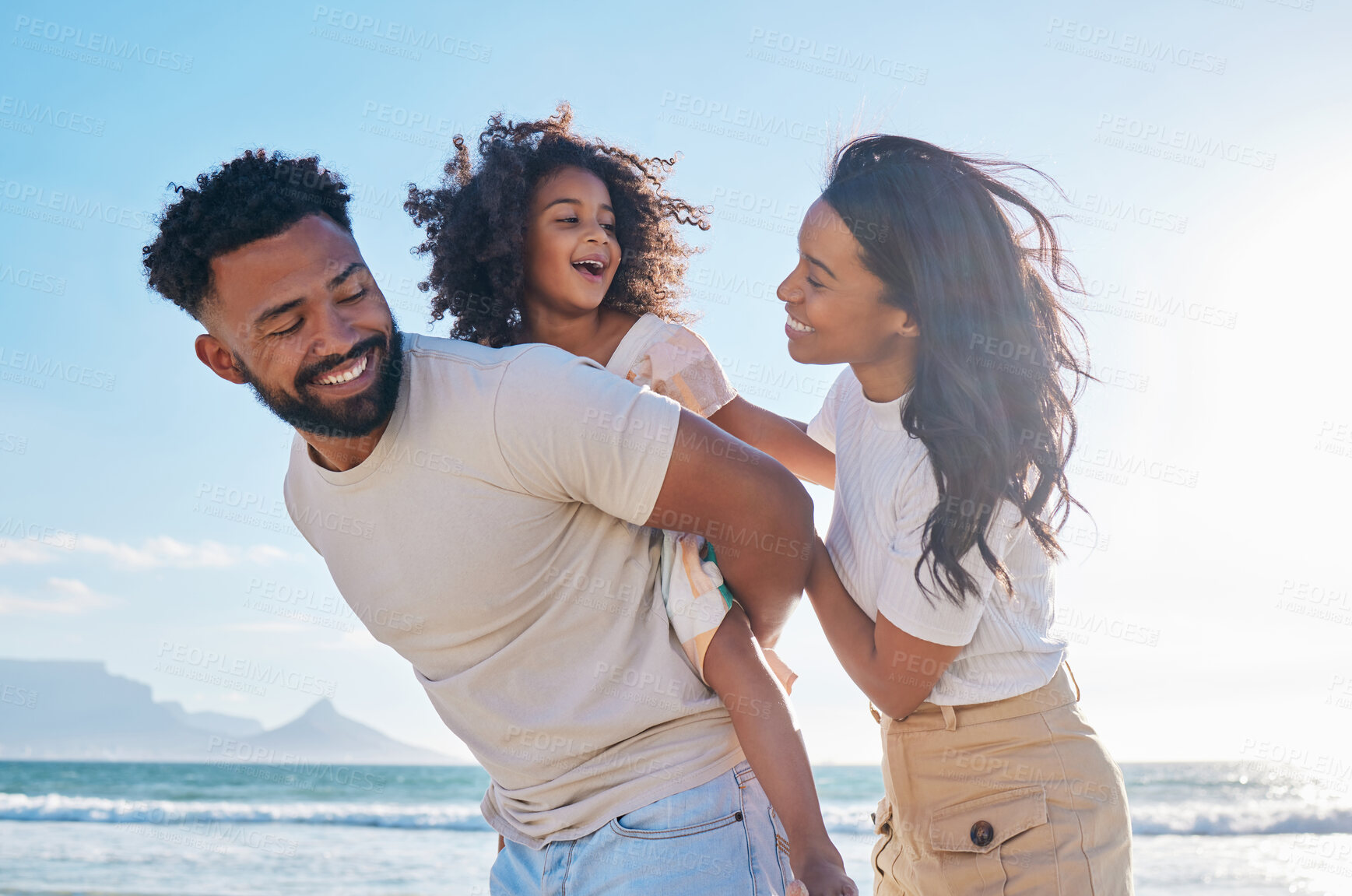 Buy stock photo Happy family, travel and parents with a child at the beach excited for a sea or ocean vacation together in happiness. Young, mother and father playing piggyback with a kid on a holiday in summer