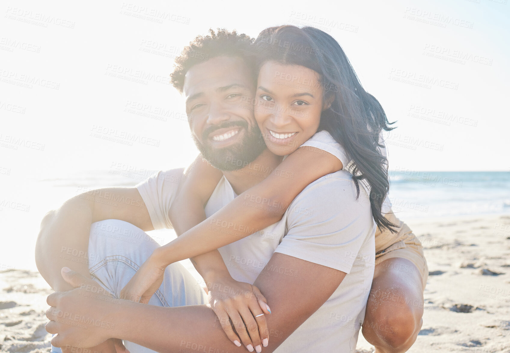 Buy stock photo Cropped portrait of an affectionate young couple sitting on the beach