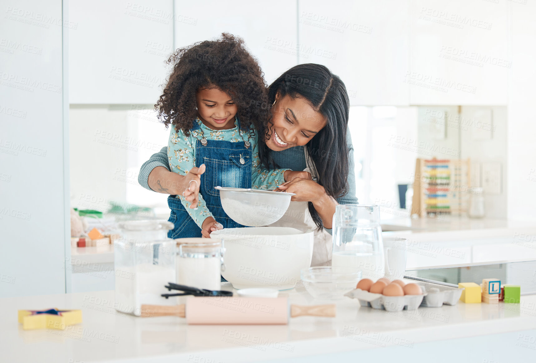 Buy stock photo Cropped shot of an attractive young woman and her daughter baking in the kitchen at home