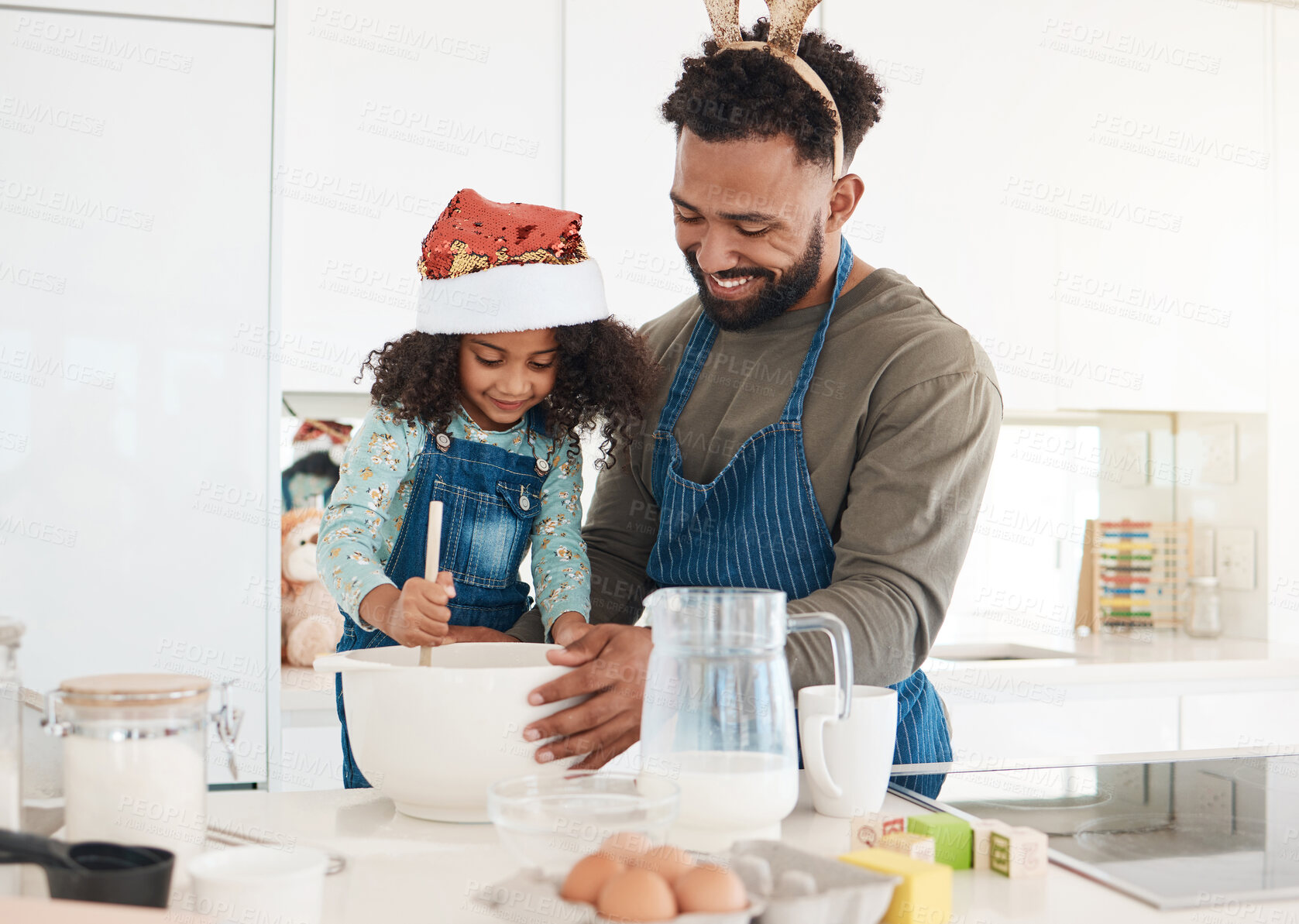 Buy stock photo Cropped shot of a handsome young man and his daughter baking in the kitchen at home