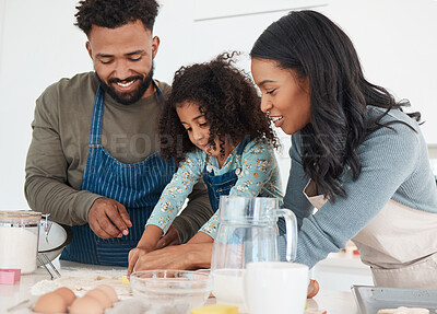 Buy stock photo Cropped shot of an affectionate young couple and their daughter baking in the kitchen at home