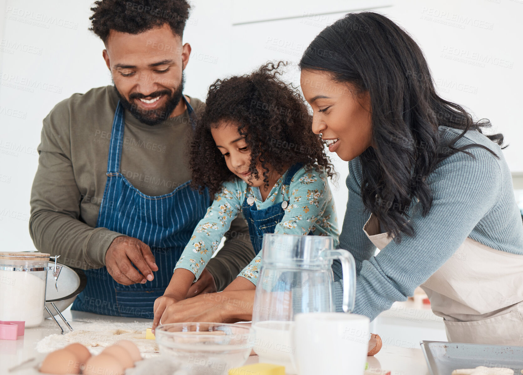 Buy stock photo Cropped shot of an affectionate young couple and their daughter baking in the kitchen at home