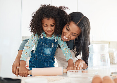 Buy stock photo Cropped shot of an attractive young woman and her daughter baking in the kitchen at home