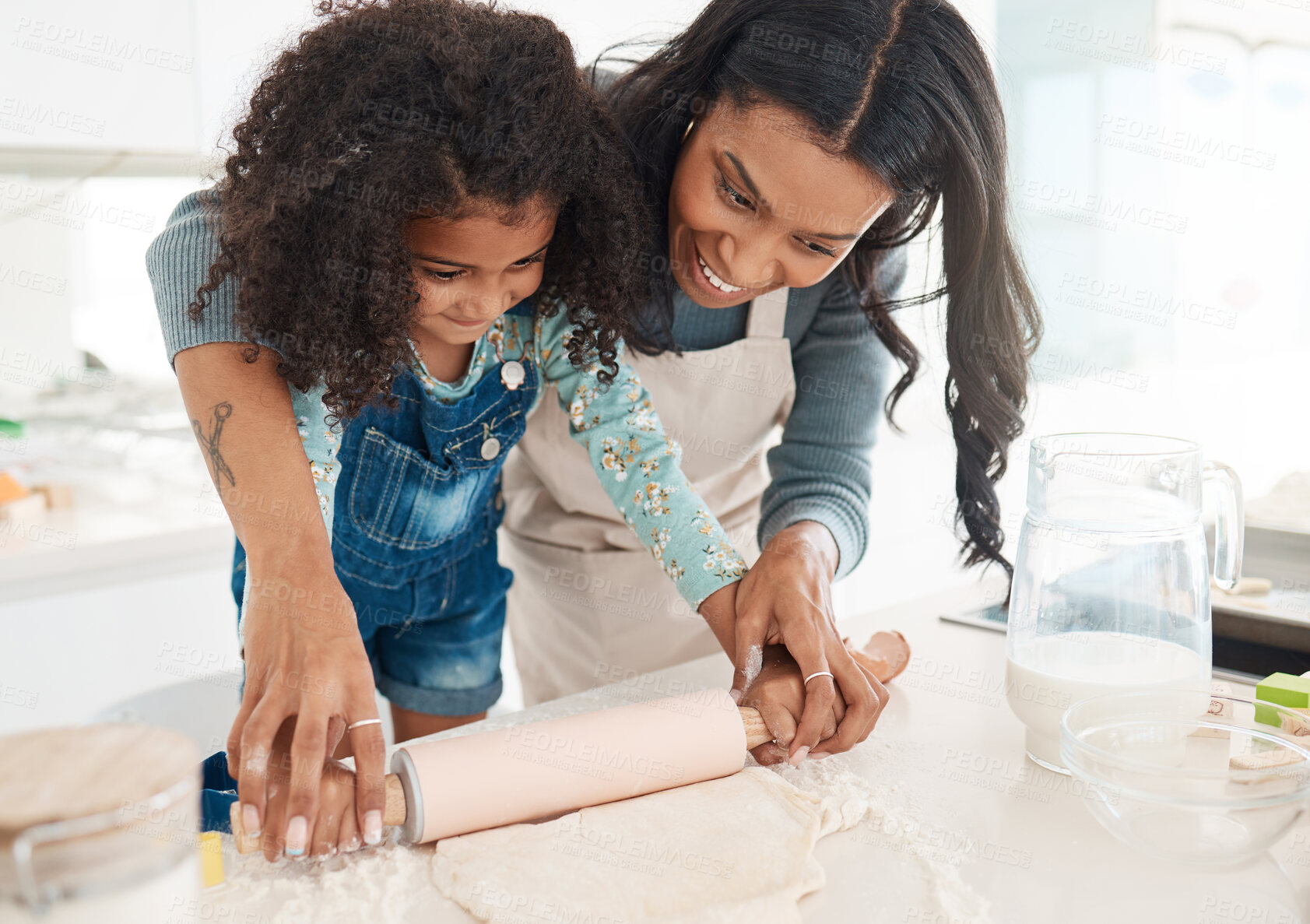 Buy stock photo Cropped shot of an attractive young woman and her daughter baking in the kitchen at home