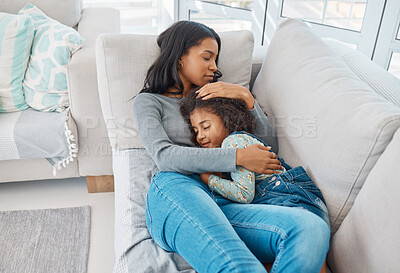 Buy stock photo Shot of a mother and daughter lying on the sofa at home