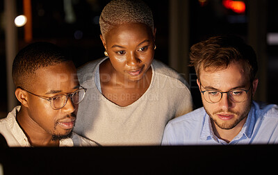 Buy stock photo Shot of a group of businesspeople working together on a computer in an office at night
