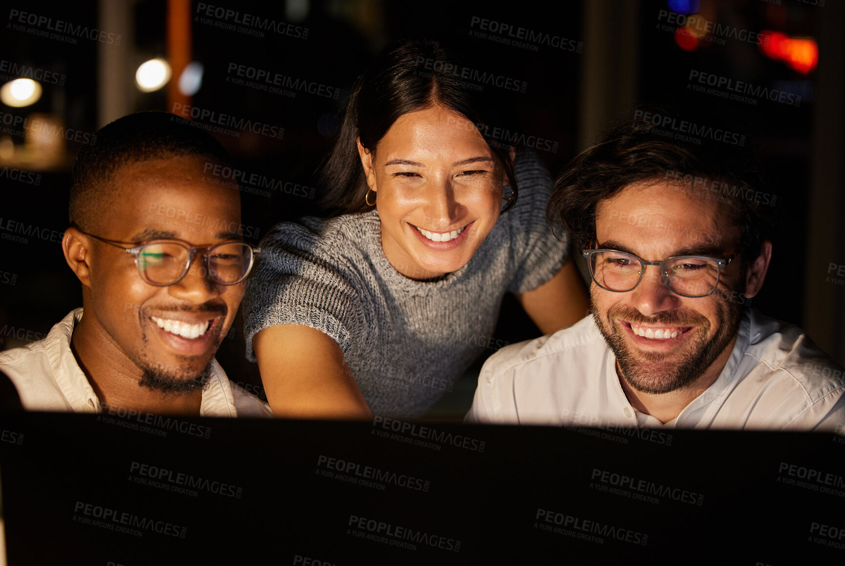 Buy stock photo Shot of a group of businesspeople working together on a computer in an office at night