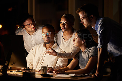 Buy stock photo Shot of a group of businesspeople working together on a computer in an office at night