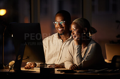 Buy stock photo Shot of two businesspeople working together on a computer in an office at night