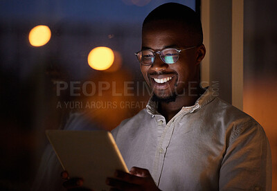 Buy stock photo Shot of a young businessman using a digital tablet in an office at night