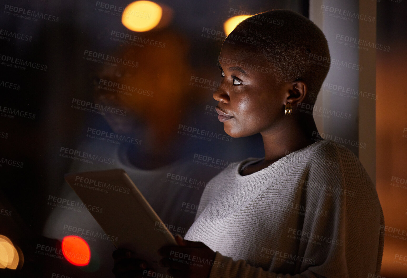 Buy stock photo Shot of a young businesswoman looking thoughtful while using a digital tablet in an office at night