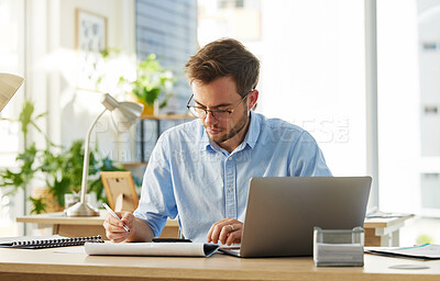 Buy stock photo Shot of a young male businessman working on his finances