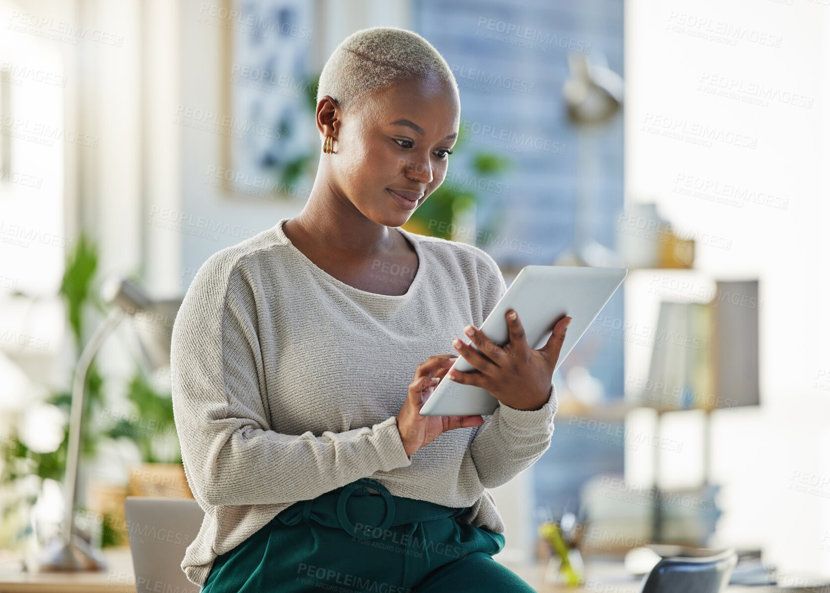 Buy stock photo Shot of a young businesswoman using a digital tablet in her office