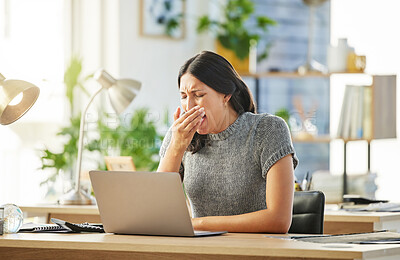 Buy stock photo Shot of a young businesswoman yawning at her desk