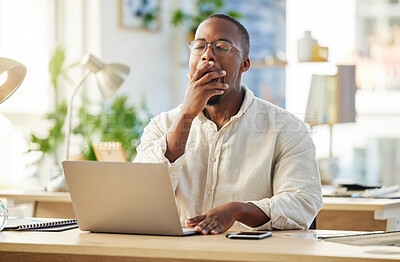 Buy stock photo Shot of a young businessman yawning while sitting at his desk