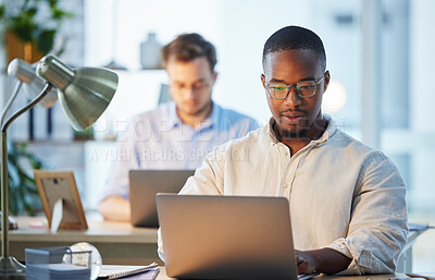 Buy stock photo Shot of two businessmen working together in their office