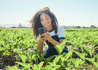 Buy stock photo Shot of a young female farmer texting while in the field