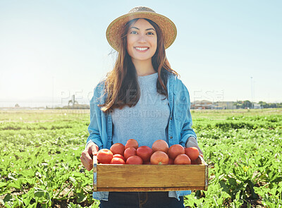 Buy stock photo Shot of a female farmer holding a crate of freshly harvested tomatoes