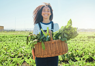 Buy stock photo Shot of a young farmer holding a basket of freshly harvested veggies