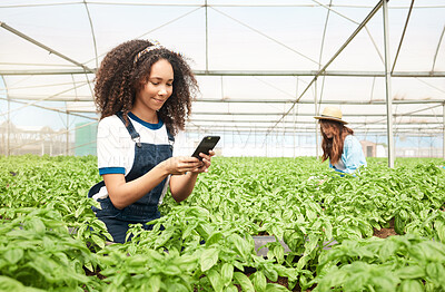 Buy stock photo Shot of a young woman using a cellphone while working on a farm