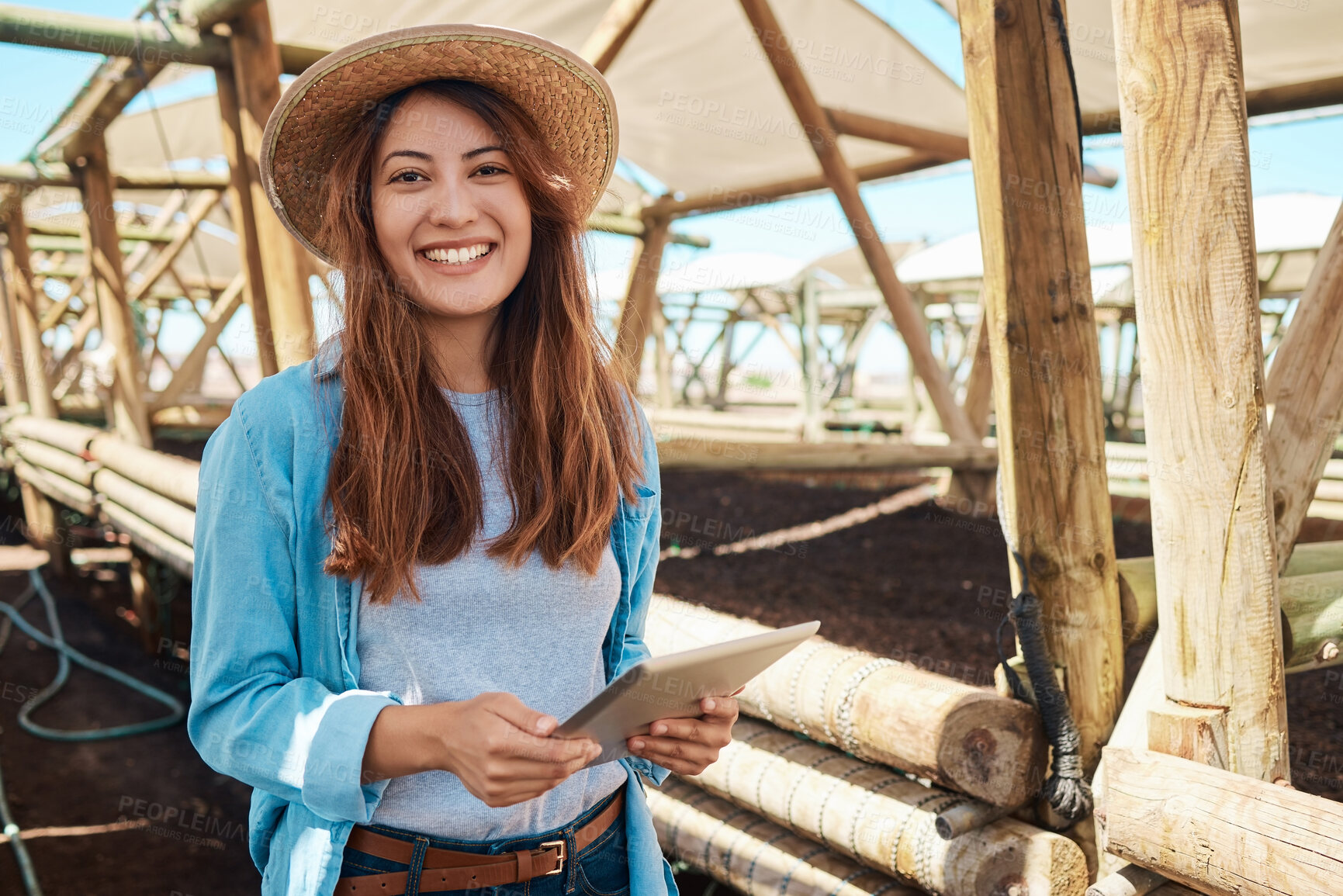 Buy stock photo Portrait of a young woman using a digital tablet while working on a farm