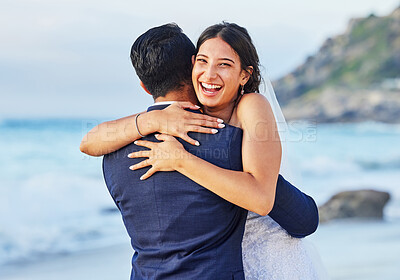 Buy stock photo Shot of a young couple on the beach on their wedding day