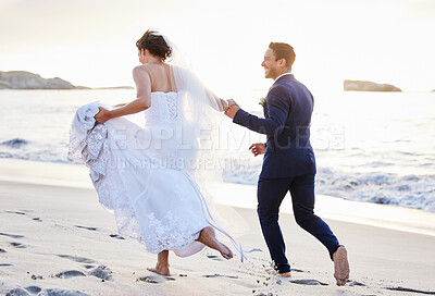 Buy stock photo Shot of a young couple on the beach on their wedding day