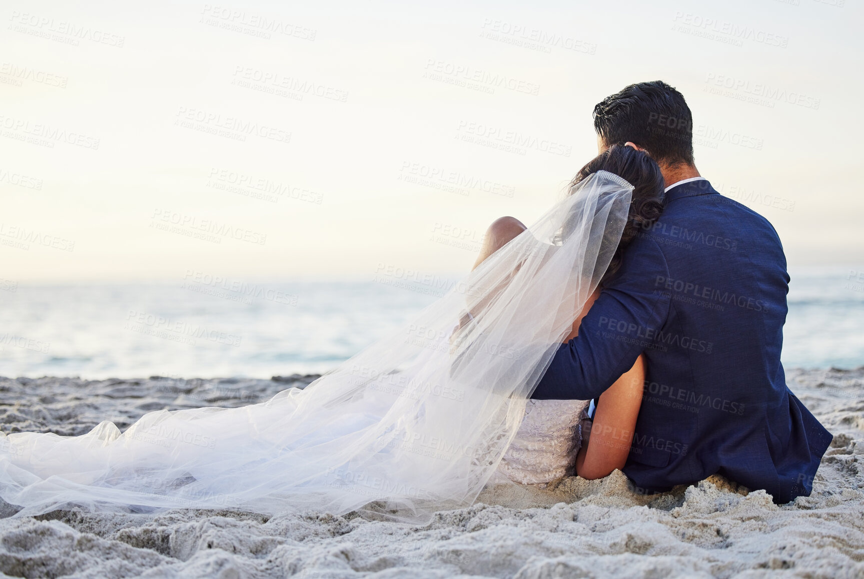 Buy stock photo Shot of a young couple on the beach on their wedding day