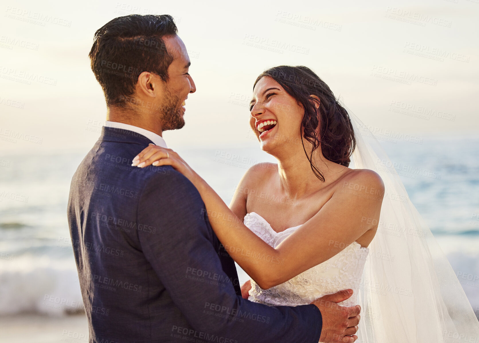 Buy stock photo Shot of a young couple on the beach on their wedding day