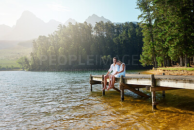 Buy stock photo Love, relax and pier with couple at lake for bonding, romance and affectionate date. Nature, travel and holiday with man and woman cuddling on boardwalk in countryside for happy, summer and vacation