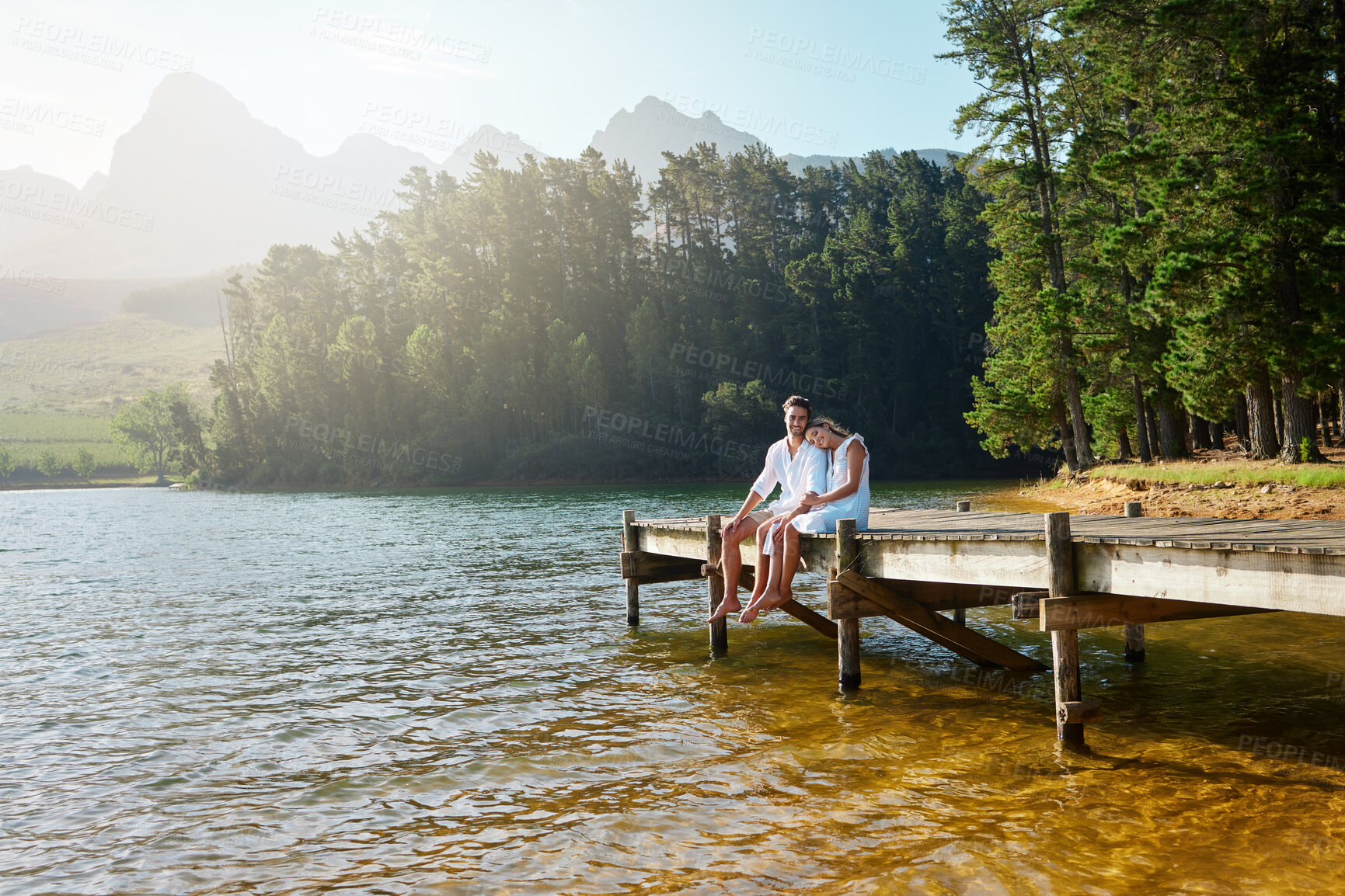 Buy stock photo Love, relax and pier with couple at lake for bonding, romance and affectionate date. Nature, travel and holiday with man and woman cuddling on boardwalk in countryside for happy, summer and vacation