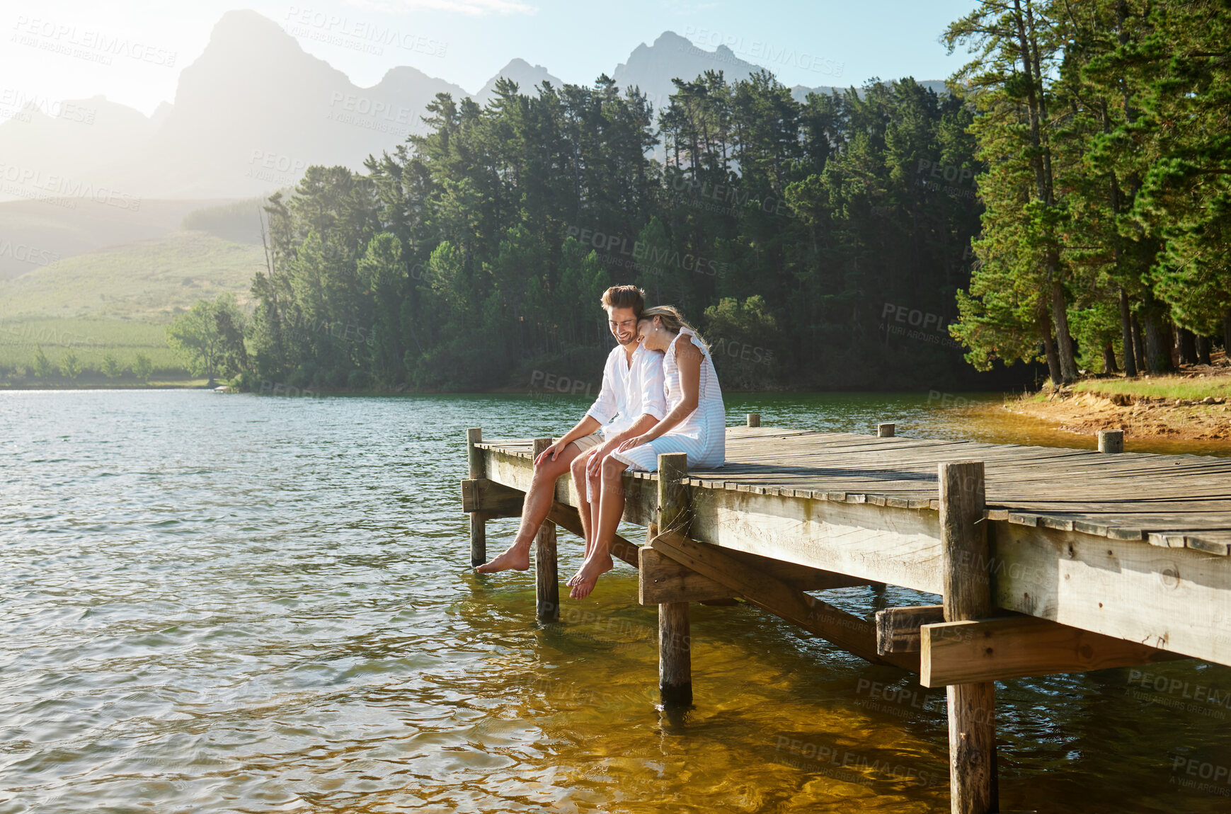 Buy stock photo Love, happy and deck with couple at lake for bonding, romance and affectionate date. Nature, travel and holiday with man and woman cuddling on boardwalk in countryside for view, summer and vacation