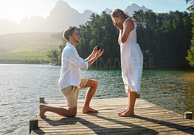 Buy stock photo Man, woman and marriage proposal by lake on vacation with surprise, wow or happiness in sunshine. Couple, engagement and offer ring in nature for romance, love and happy on holiday in summer by water