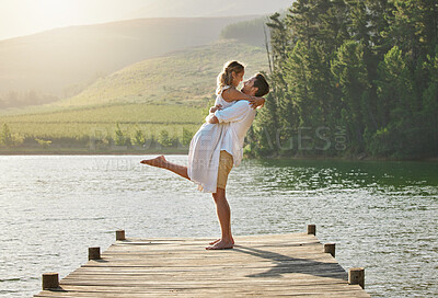 Buy stock photo Couple, lake hug and engagement announcement of young people in love in nature. Happy, relax and happiness of woman and man together by water outdoor on summer vacation by a lakeside on holiday break