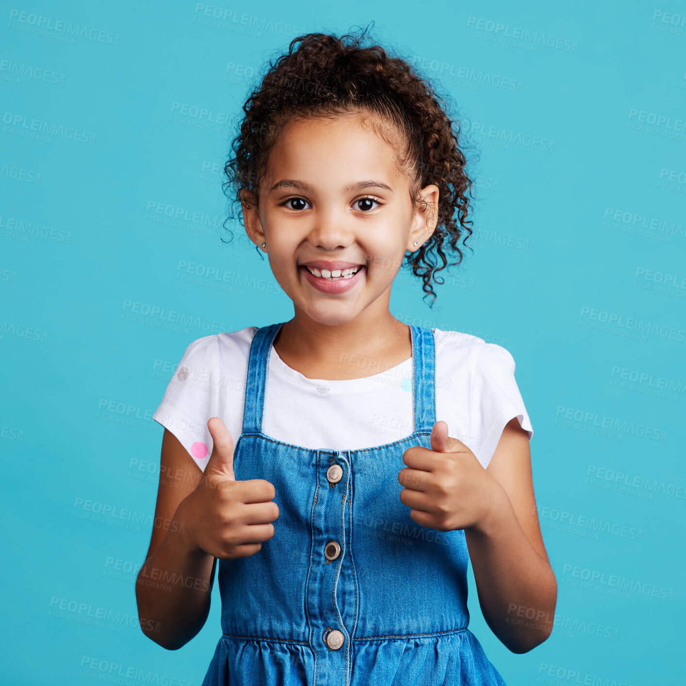 Buy stock photo Happy, thumbs up and portrait of a child in a studio with success, happiness and achievement. Smile, positive and face of a girl kid with a satisfaction or approval hand gesture by a blue background.