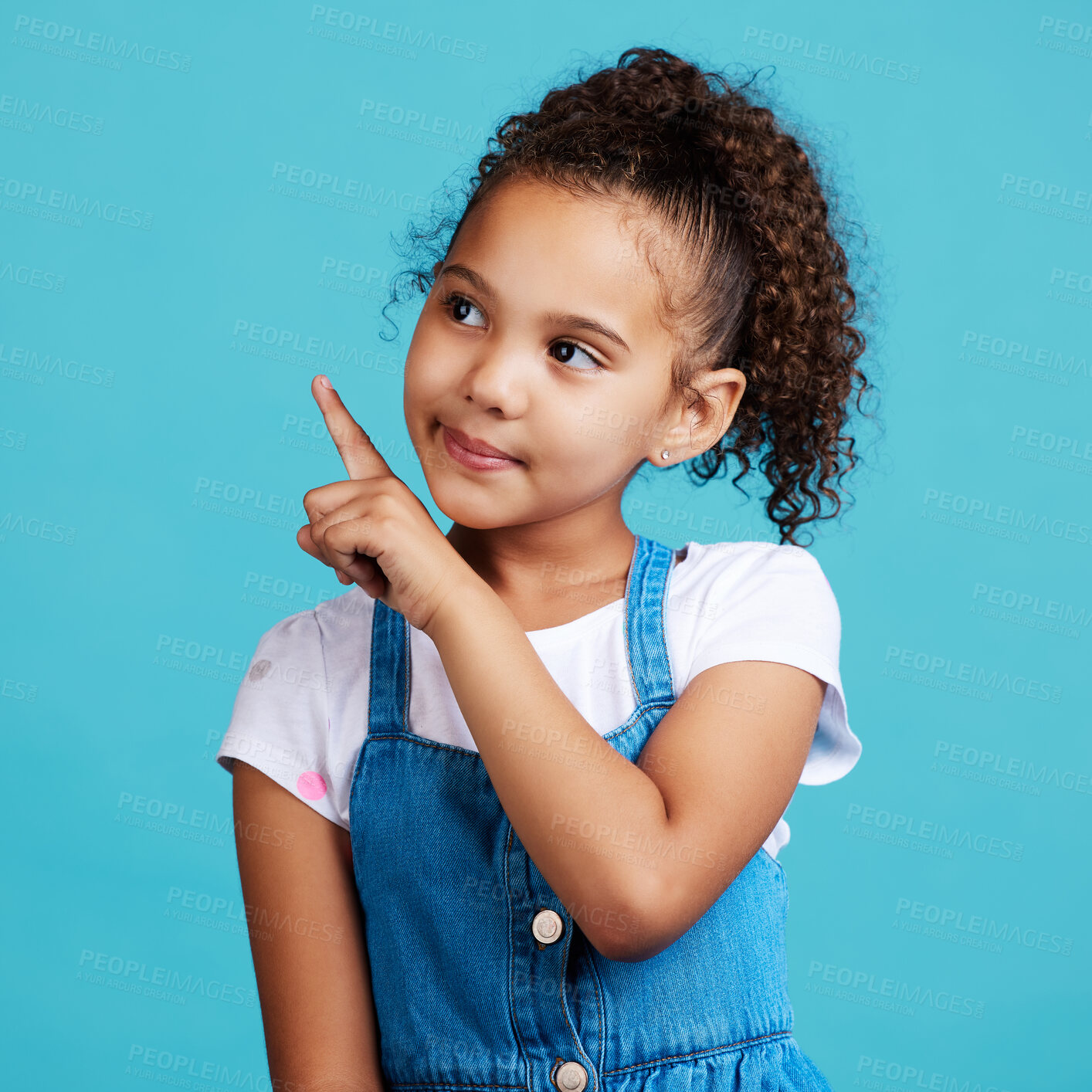 Buy stock photo Girl child, thinking and point in studio with idea, looking and young with mind development by blue background. Female kid, pointing finger and focus with fashion, kids clothes or mindset by backdrop