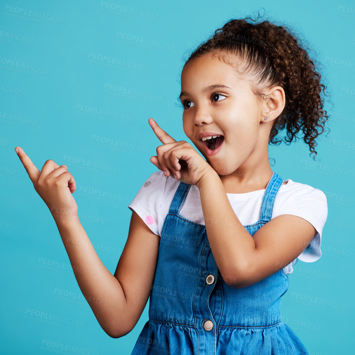 Buy stock photo Wow, pointing and a girl on a blue background in studio for marketing with product placement space. Kids, surprise and hand gesture with an adorable little female child showing mockup for advertising