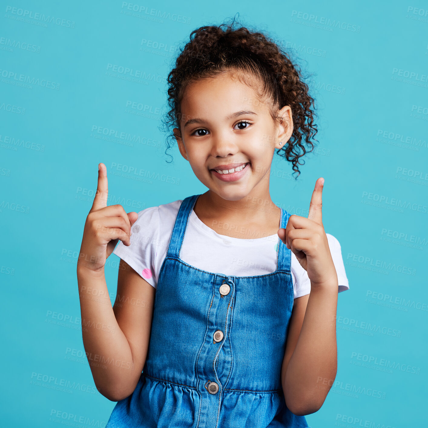 Buy stock photo Portrait, point and mockup with a girl on a blue background in studio showing product placement space. Kids, marketing and advertising with an adorable female child pointing at branding indoor