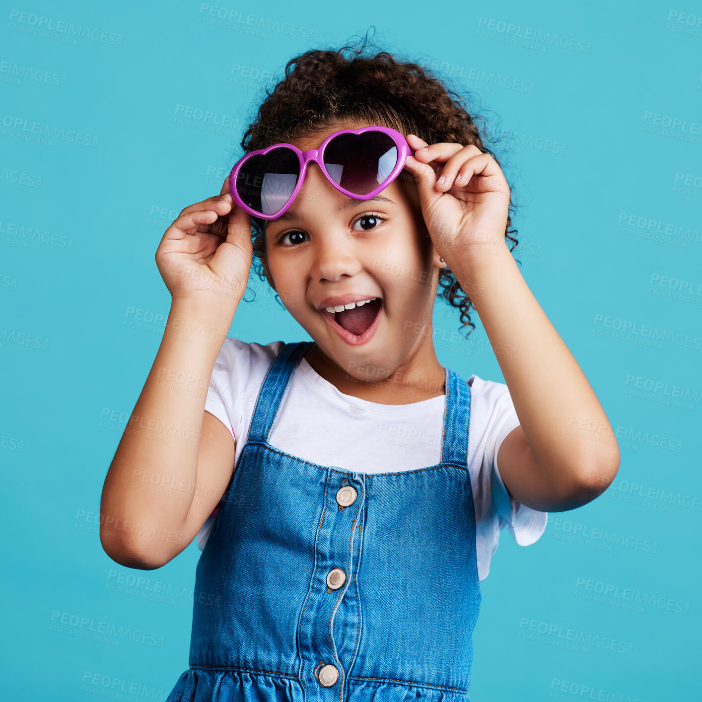 Buy stock photo Happy, sunglasses and portrait of a child in studio with a positive, shocked and excited face expression. Happiness, surprise and girl kid model with funky, trendy and cool glasses by blue background