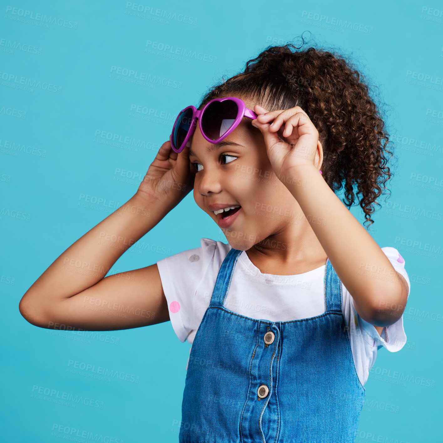 Buy stock photo Happy, smile and of a child with sunglasses in studio with positive, energy and excited face expression. Happiness, childhood and girl kid model with funky, trendy and cool glasses by blue background