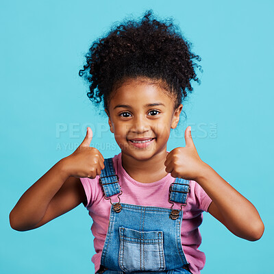 Buy stock photo Little girl, portrait smile and thumbs up for winning, good job or success against a blue studio background. Happy child face smiling showing hand thumb emoji, yes sign or like for agreement or win